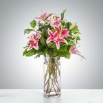 Tall glass vase of pink stargazer lilies with buds and foliage