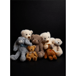 Assorted teddy bears and plush animals posed against a black background