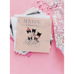 Stack of Christmas napkins with cat illustrations on a pink background