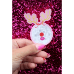 Hand holding a festive reindeer disco ball sticker against a pink glitter background