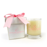 White gift box with pink ribbon next to a cream-colored candle in a clear glass jar