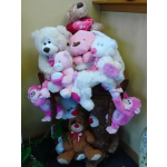 Cluster of teddy bears holding heart pillows in pink and white