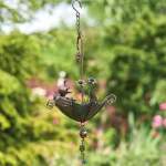 Metal hanging bird feeder with a small bird figure and flower accents
