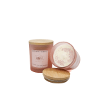 Pink rose-scented candle in a glass jar with a wooden lid
