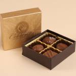 Small box of assorted milk chocolates in an open brown and gold gift box