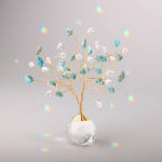 Decorative gold wire tree with turquoise and clear crystals in a faceted glass base