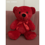 Red plush teddy bear with a satin bow sitting on a chair