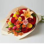 Bouquet of mixed red, orange, pink, and yellow flowers wrapped in paper