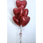 Cluster of red heart-shaped balloons tied with curling ribbons