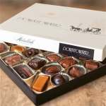 Open box of assorted chocolates in paper cups