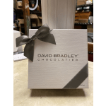 A boxed David Bradley Chocolatier gift set with a gray ribbon