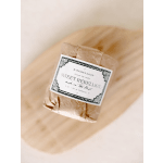 Wrapped candle with a labeled paper tag