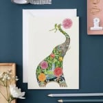 Greeting card with a colorful elephant illustration and pink flower