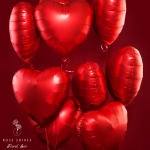 Cluster of red heart-shaped balloons on a red background