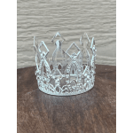 Silver jeweled crown on a wooden surface