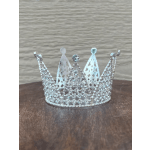 A silver rhinestone crown on a wooden surface