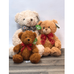 Three plush teddy bears with bows sit together on a wooden surface.