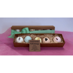 Gift boxes with five pastel bath bombs on straw filler