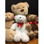 Plush teddy bears with red ribbon bows grouped together