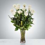 Tall bouquet of white roses in a clear glass vase