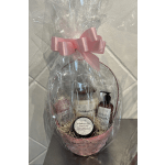 Gift basket with cranberry fig bath products wrapped in clear cellophane and a pink bow