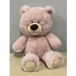 Pink plush teddy bear sitting upright on a table