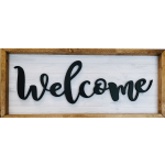 Black "welcome" sign in a wooden frame on a white plank background