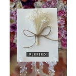 White card with dried baby's breath tied with twine and the word BLESSED