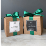 Two boxed candles tied with green ribbon