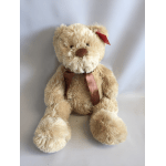 Plush teddy bear with a ribbon bow and red tag