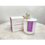 Soy wax candle in a white container with a pink floral sprig on top