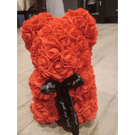Orange teddy bear made of rose-shaped flowers with a black ribbon