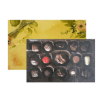 Rectangular gift box of assorted chocolates with a yellow floral lid and gold ribbon.