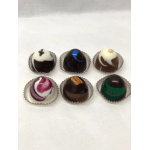 Six assorted chocolate truffles in paper cups on a white surface