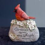 Cardinal figurine on a stone-look memorial plaque with flowers