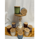 Assorted scented candles in textured glass jars on a pedestal stand