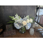 White and pale blue flower arrangement in a glass vase
