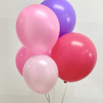 Cluster of pink, purple, and red balloons against a plain background