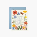 Birthday card with colorful flowers and butterflies in front of a blue envelope