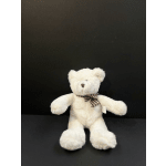 White teddy bear with a plaid bow on a dark background
