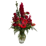 Red mixed flower arrangement in a clear glass vase