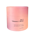Pink cylindrical candle jar labeled Tobacco + Wood