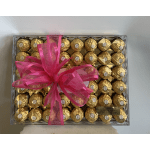 Box of gold-wrapped chocolates tied with a bright pink ribbon