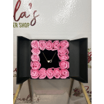 Pink roses arranged in a square gift box with a heart necklace in the center