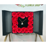 Box of red roses with a necklace in the center