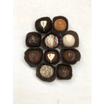 Assorted chocolate truffles with varied toppings arranged in a circle on a white background