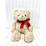 Cream teddy bear with a red ribbon bow