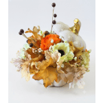 Orange and cream floral arrangement in a white pumpkin container
