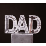 Decorative "DAD" sign made from tools and hardware on a pedestal