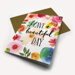 Greeting card with watercolor flowers and the message Have a Beautiful Day, shown with a brown envelope